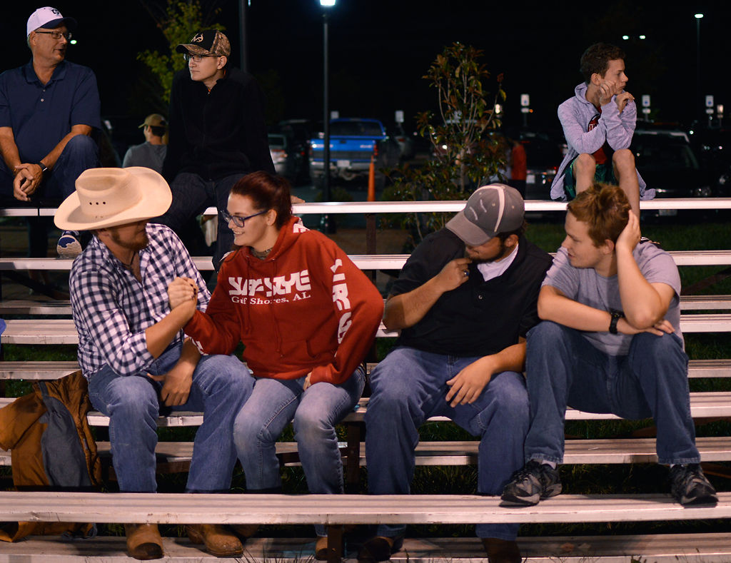 Austin Luecke and Sabrina Johnson arm-wrestle while Matthew Coules and Will Samuels watch